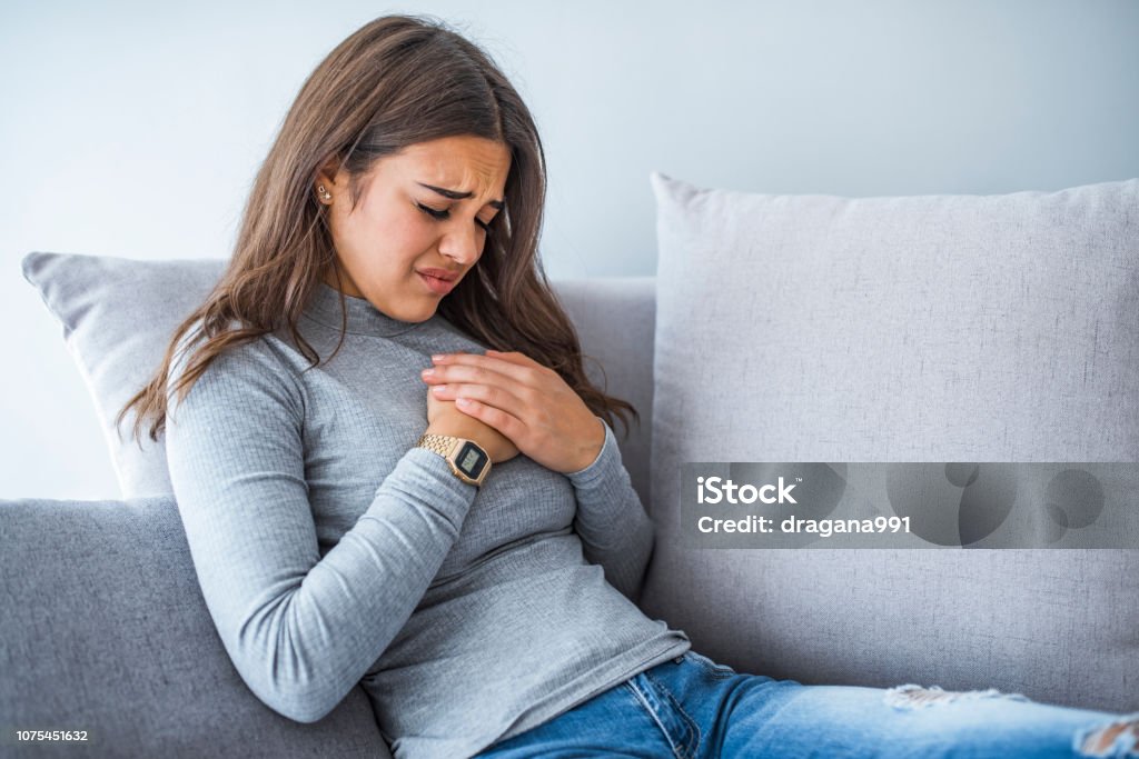 Sick woman having bad ache and pain heart attack health problem Aches and pains concept. Sick woman having bad ache and pain heart attack health problem. Female placing hands on her chest. Woman is clutching her chest, acute pain possible heart attack Women Stock Photo