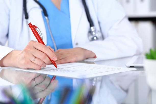 istock Woman doctor using tablet computer while sitting at the desk  in hospital office, closeup. Healthcare, insurance and medicine concept 1075452414