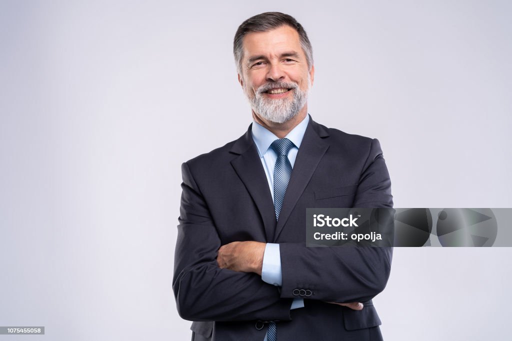 Happy satisfied mature businessman looking at camera isolated on white background. Happy satisfied mature businessman looking at camera isolated on white background Businessman Stock Photo
