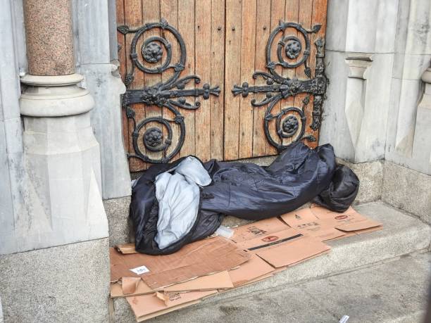 persona sin hogar fuera de la puerta de la iglesia - republic of ireland sadness household equipment northern europe fotografías e imágenes de stock