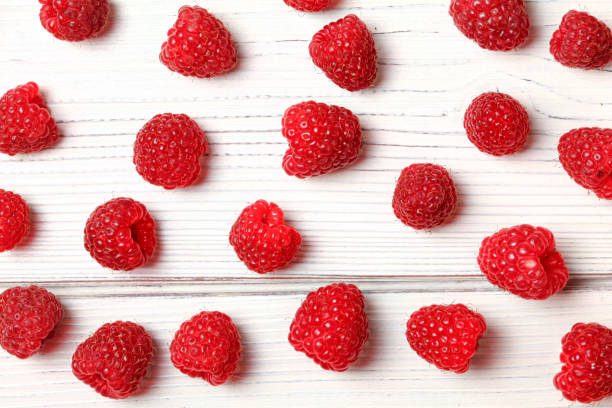 istock Tabletop view, raspberries spilled on white boards. 1075456970