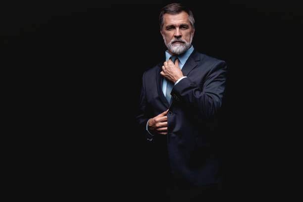 istock Handsome mature business man isolated on black background 1075457038