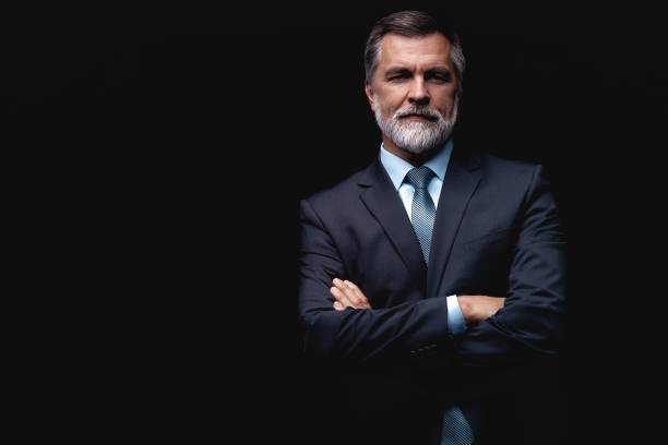 istock Handsome mature business man isolated on black background 1075457042