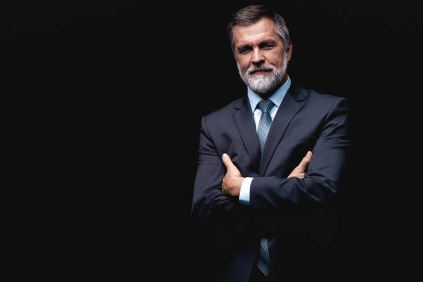 istock Handsome mature business man isolated on black background 1075457044
