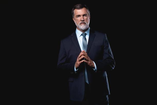 istock Handsome mature business man isolated on black background 1075457050