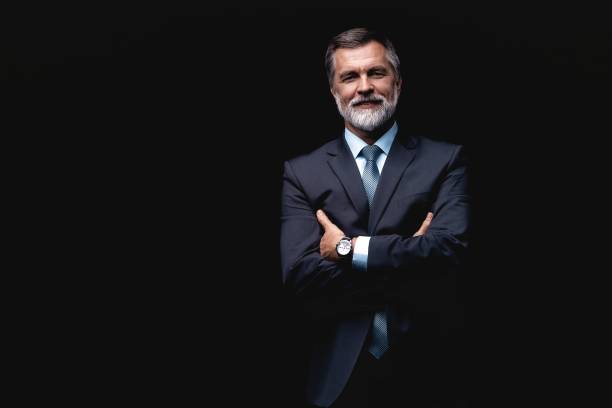 istock Handsome mature business man isolated on black background 1075457058