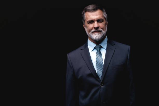 istock Handsome mature business man isolated on black background 1075457074