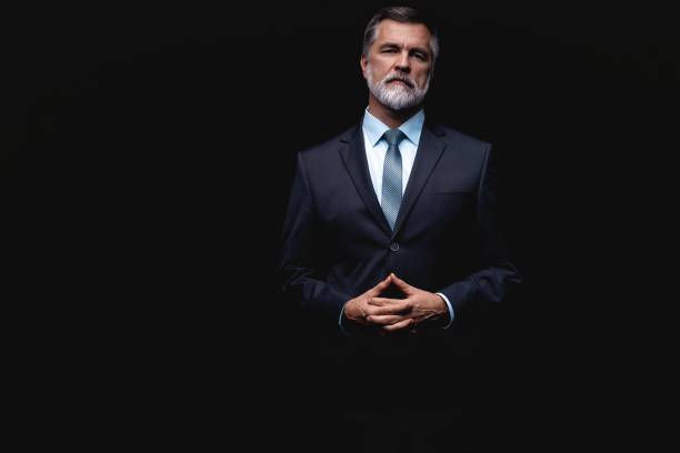 istock Handsome mature business man isolated on black background 1075457122