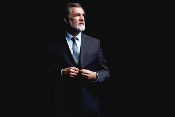 istock Handsome mature business man isolated on black background 1075457144