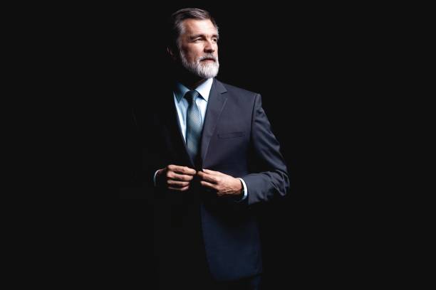 istock Handsome mature business man isolated on black background 1075457158