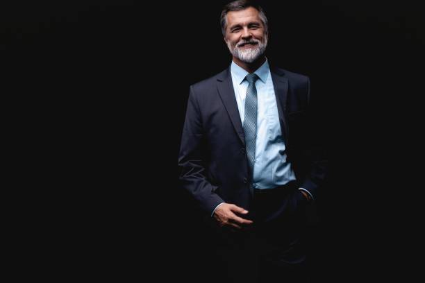 istock Handsome mature business man isolated on black background 1075457166