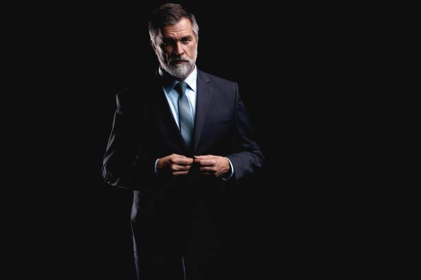 istock Handsome mature business man isolated on black background 1075457196