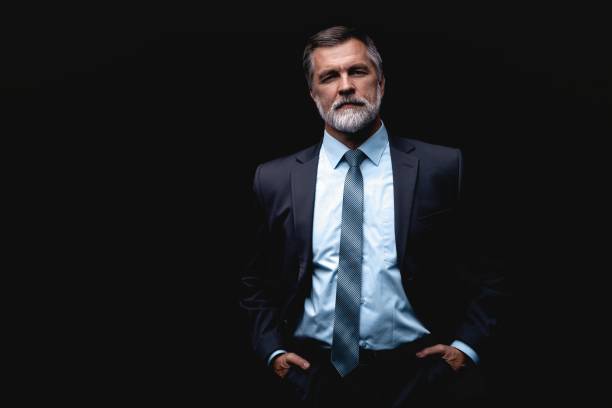 istock Handsome mature business man isolated on black background 1075457200