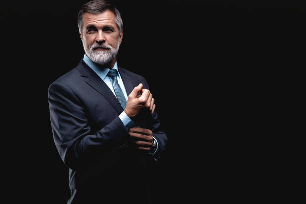 istock Handsome mature business man isolated on black background 1075457204