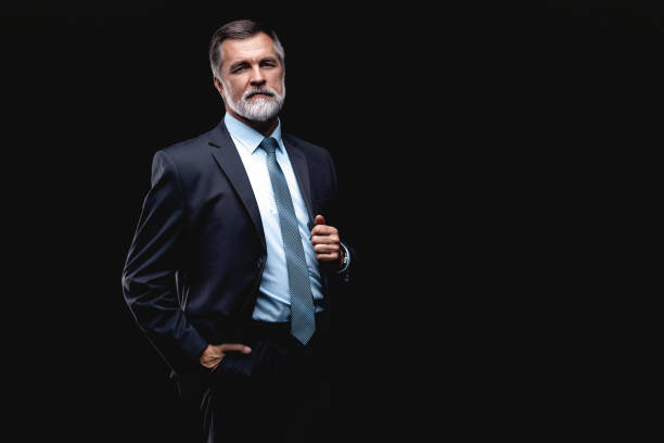 istock Handsome mature business man isolated on black background 1075457208