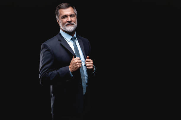 istock Handsome mature business man isolated on black background 1075457236