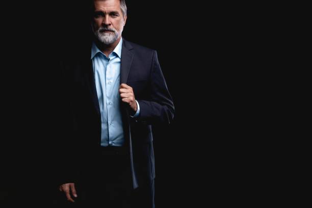 istock Handsome mature business man isolated on black background 1075457250