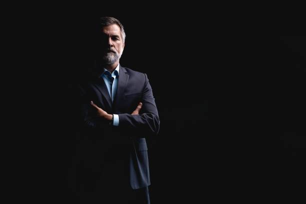 istock Handsome mature business man isolated on black background 1075457350