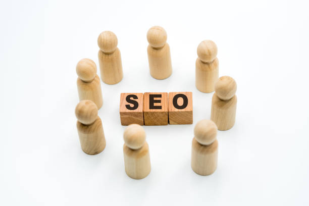 istock Wooden figures as business team in circle around acronym SEO Search Engine Optimization 1075457650