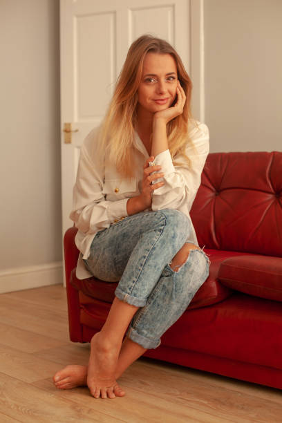 istock Blond Girl, Red Sofa, Wood floor 1075458690