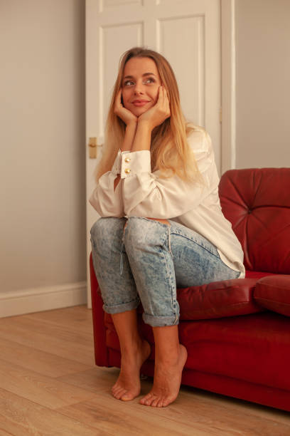 istock Blond Girl, Red Sofa, Wood floor 1075459346
