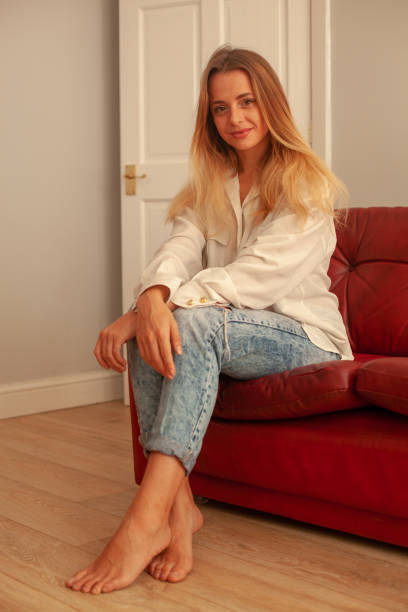istock Blond Girl, Red Sofa, Wood floor 1075459718