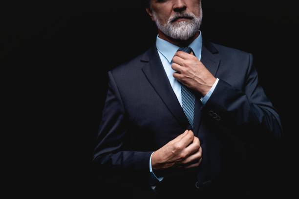 Man in a suit fixing his tie. Well dressed business man adjusting his neck tie man adjusting tie stock pictures, royalty-free photos & images