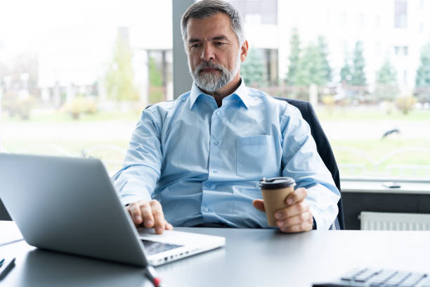 istock Senior businessman working on laptop computer in the office. 1075464096