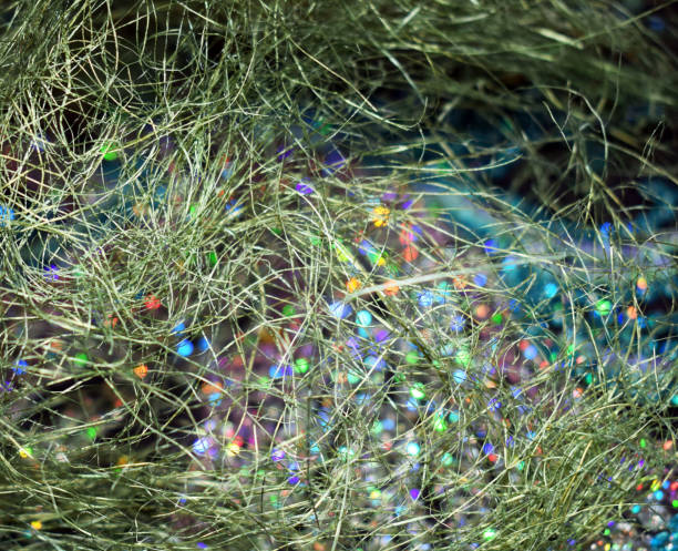 istock Christmas background. Brilliant colorful lights. Colored spots on dark background. Intertwined threads. Green cobwebs. 1075464452