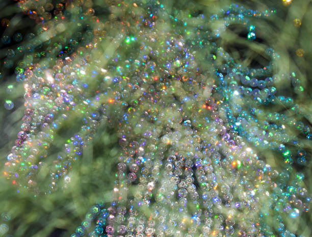 istock Christmas background. Brilliant colorful lights. Colored spots on dark background. Intertwined threads. Green cobwebs. 1075464492