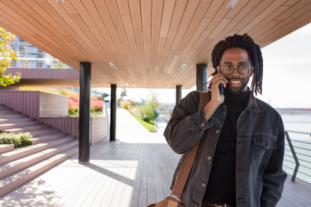 istock Smiling man talking on a mobile phone outdoors 1075467858