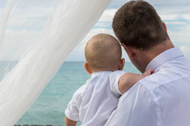 een vader en zijn jonge zoon in een huwelijksfeest - foto’s van jongen stockfoto's en -beelden