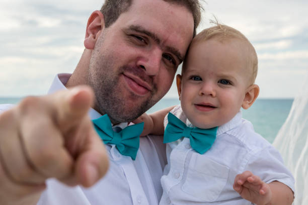 een vader en zijn jonge zoon in een huwelijksfeest - foto’s van jongen stockfoto's en -beelden