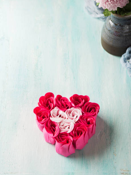 istock Heart shaped pink red roses on pastel color 1075472364
