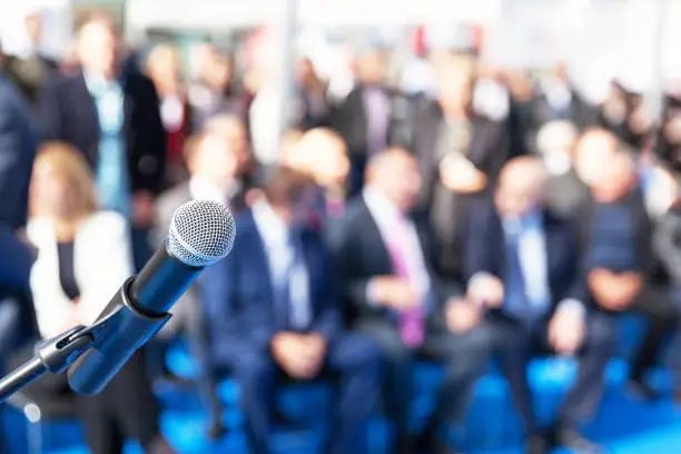 Microphone in focus against blurred audience