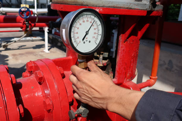 tecnico uomo tenendo indicatore per controllare la pressione del tubo nel settore - valve gauge pipe physical pressure foto e immagini stock