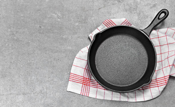 Cast iron pan on a grunge concrete background Cast iron pan on a grunge concrete background with copy space. Empty iron pan, top view or high angle shot. skillet stock pictures, royalty-free photos & images