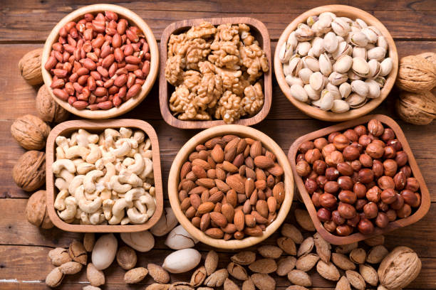 istock bowls of nuts on wooden table, top view 1075504680