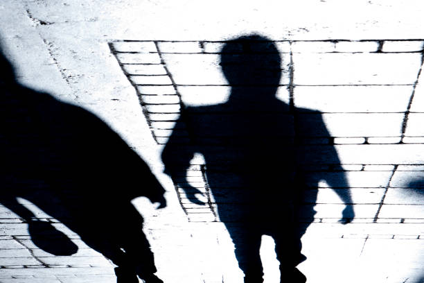 istock Blurry shadow of two people walking in the night 1075515126