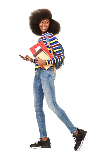 핸드폰과 책 가방 걷는 행복 한 젊은 흑인 여자의 초상화를 측면 - student printed media walking clothing 뉴스 사진 이미지