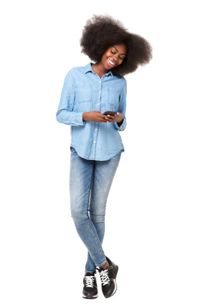 istock Full length young black woman smiling at mobile phone text message 1075520852