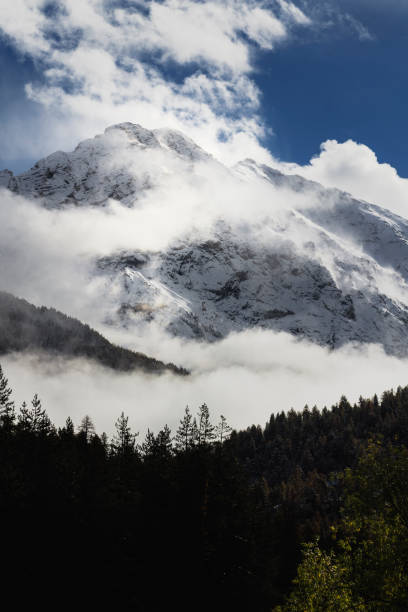 istock Snowy mountain in the clouds vertical 1075524980