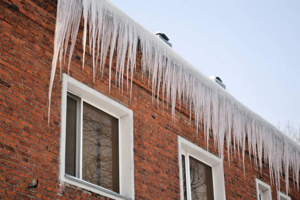 istock Long, big and dangerous icicles on a brick house roof 1075537422