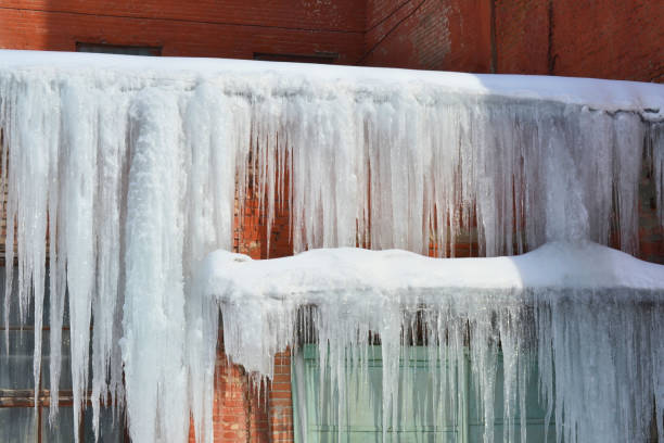Long, big and dangerous icicles on a brick house roof Long, big and dangerous icicles on a brick house roof icicle photos stock pictures, royalty-free photos & images