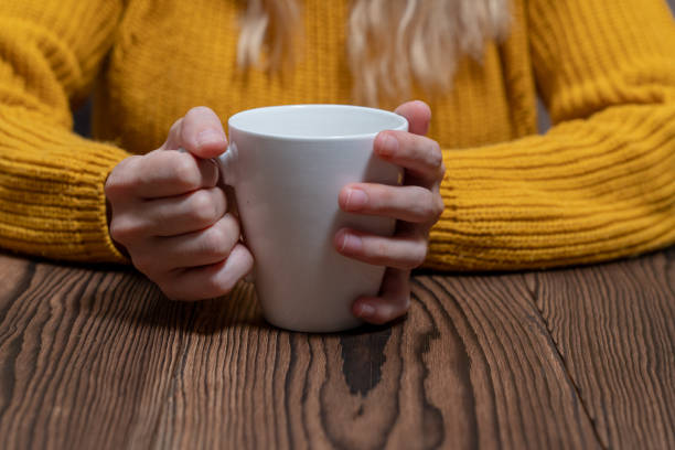 istock woman in yellow sweater is reading book while drinking coffee mock-up template 1075538286