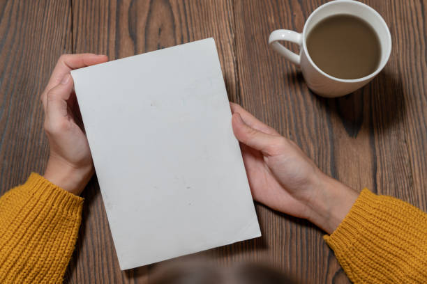 woman in yellow sweater is reading book while drinking coffee mock-up template