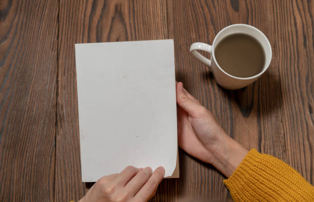 istock woman in yellow sweater is reading book while drinking coffee mock-up template 1075538296