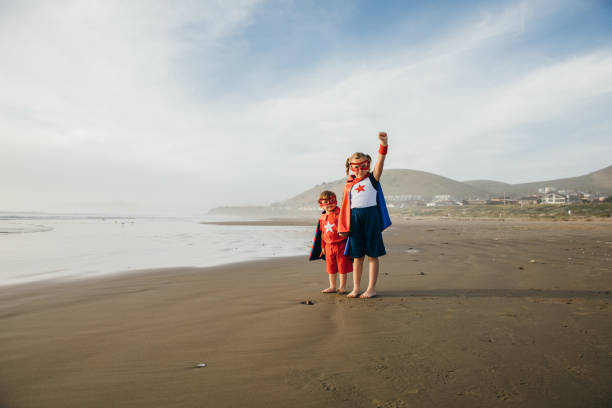 young girl and boy superheroes on california beach. - partnership creativity superhero child imagens e fotografias de stock