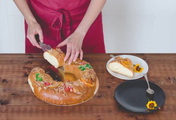istock Waitress with uniform cutting and serving cake of kings day. 1075551122