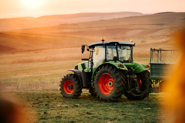 istock Harvesting details with tractor and trailer transporting harvest at sunset 1075556782